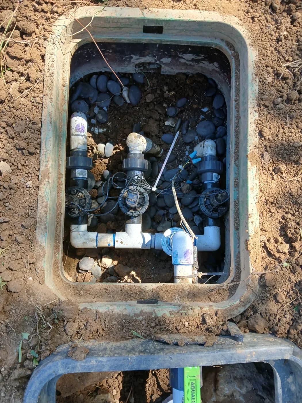 Open irrigation valve box with a rebuilt PVC manifold and three valves